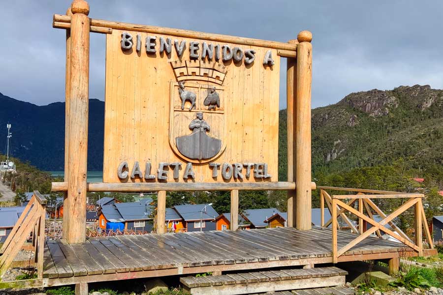 Letrero de bienvenida a Caleta Tortel en madera nativa.