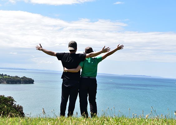 John y Camila abrazados mirando el mar en Nueva Zelanda