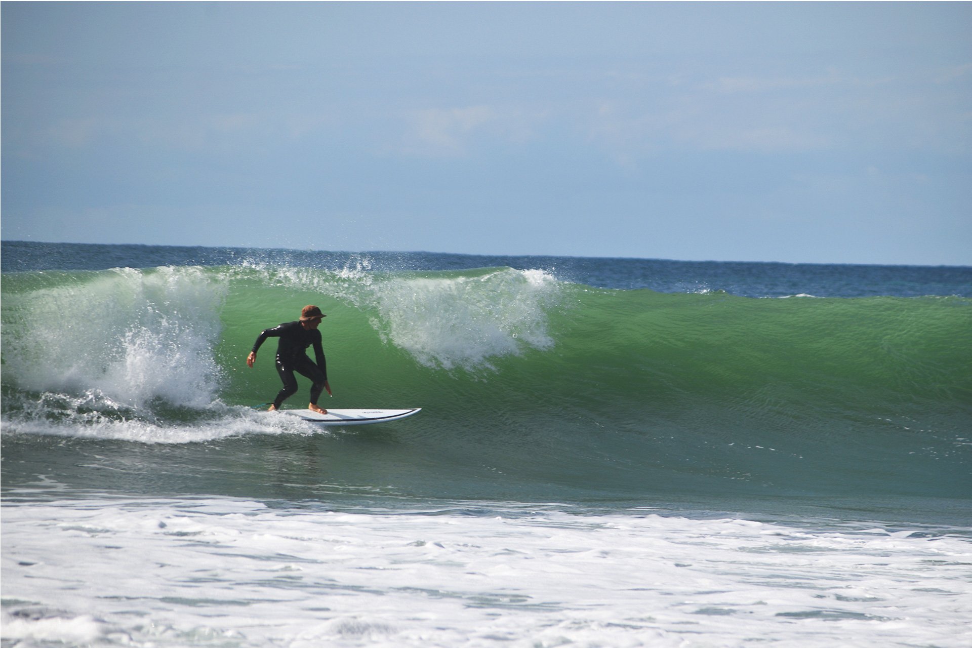 Hombre surfeando una ola en Raglan, Nueva Zelanda.