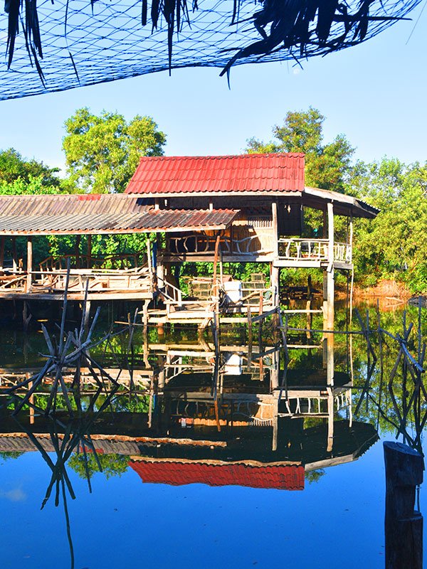 Reflejo de una casa tradicional tailandesa sobre el lago en Koh Yao Noi.